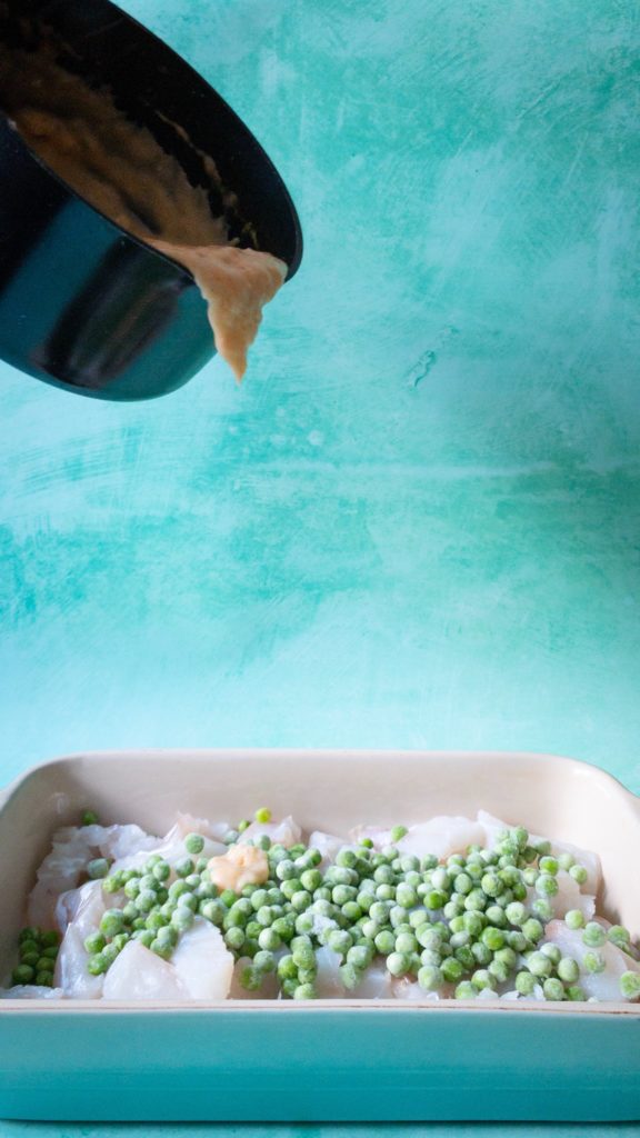 Pouring sauce onto fish and peas