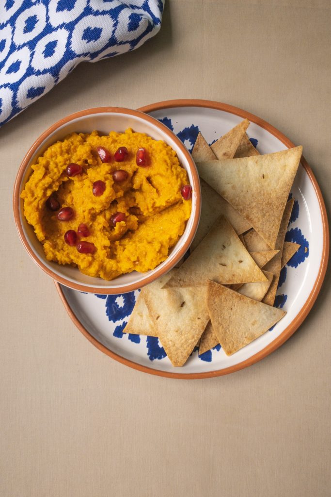 garlic and fennel baked chips with carrot and orange hummus
